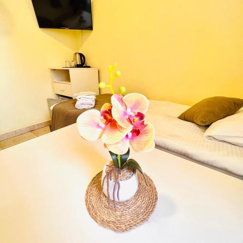 a vase with flowers on a table in a bedroom at MarNar Hotel in Yerevan