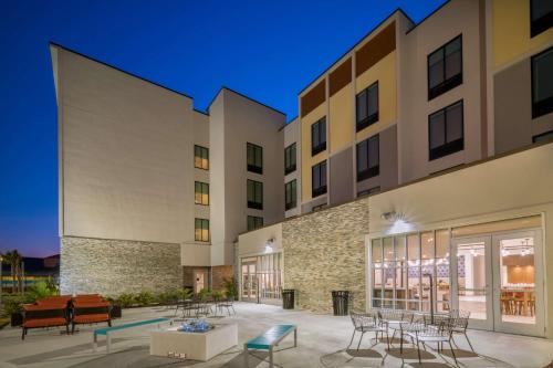 an exterior view of a building with tables and chairs at Hilton Garden Inn Brunswick in Brunswick