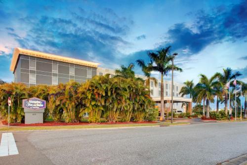 a building with palm trees in front of a street at Hampton Inn & Suites Sarasota / Bradenton - Airport in Sarasota