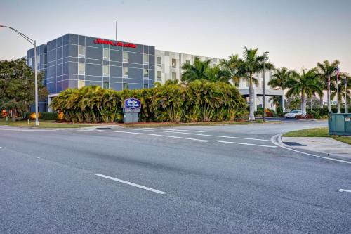 an empty street in front of a building with palm trees at Hampton Inn & Suites Sarasota / Bradenton - Airport in Sarasota