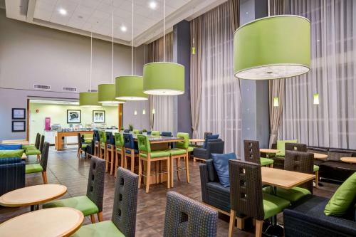a waiting room with tables and green chairs at Hampton Inn & Suites Sarasota / Bradenton - Airport in Sarasota