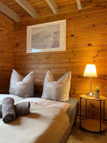 a bedroom with wooden walls with a bed and a lamp at TinyHouse Meereszauber- ruhige Lage, eigener Garten, Grill in Wolgast