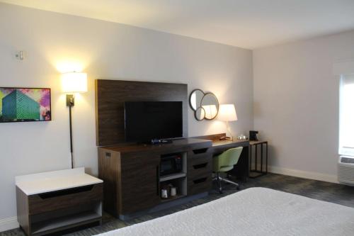 a hotel room with a bed and a desk with a television at Hampton Inn & Suites Sarasota / Bradenton - Airport in Sarasota