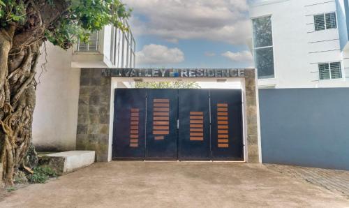 a black garage door with a sign that reads valley residence at Treebo Midvalley Residence in Yelagiri
