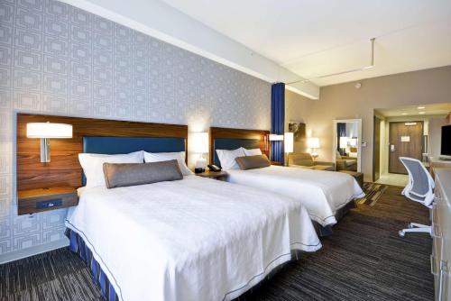 Habitación de hotel con 2 camas y sala de estar. en Home2 Suites By Hilton St. Simons Island, en Saint Simons Island