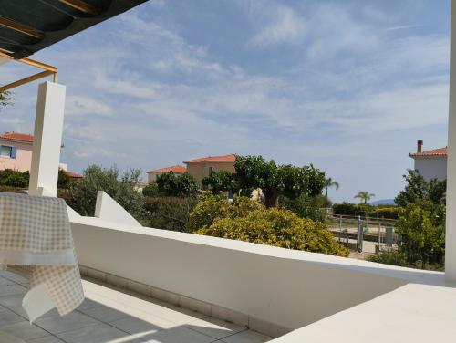 a white balcony with a white wall and trees at Calypso Two Bedroom Apartment in Kandia