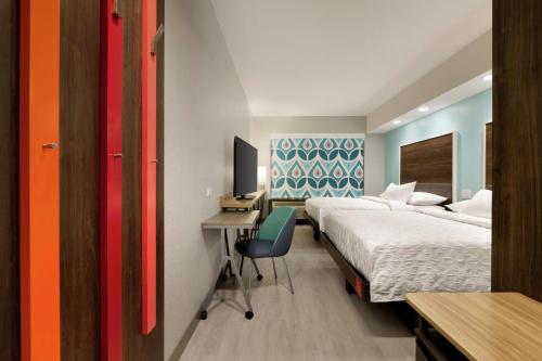 1 dormitorio con 2 camas y escritorio con ordenador en Tru by Hilton St. Charles St. Louis en St. Charles
