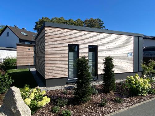 a home with a wooden facade with plants at Fichtelcube de in Schönwald