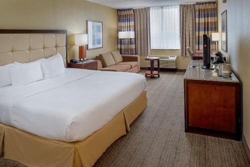 a hotel room with a large bed and a living room at DoubleTree by Hilton St. Louis at Westport in Maryland Heights