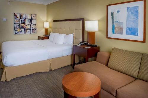 a hotel room with a bed and a couch at DoubleTree by Hilton St. Louis at Westport in Maryland Heights