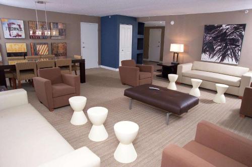 a living room with couches and a dining room at DoubleTree by Hilton St. Louis at Westport in Maryland Heights