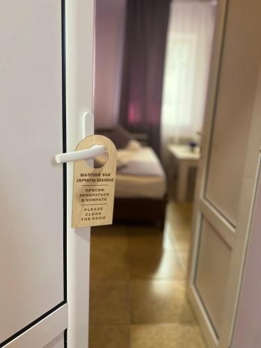 a door with a tag attached to a room with a bed at MarNar Hotel in Yerevan