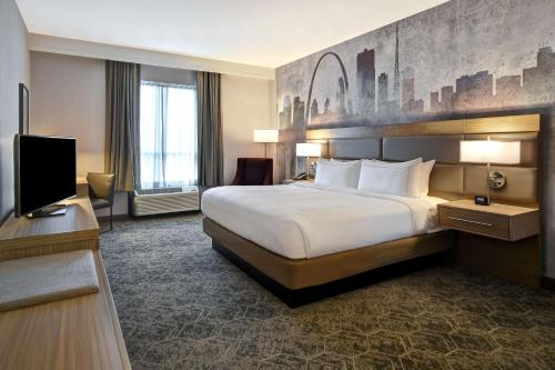 Habitación de hotel con cama y TV de pantalla plana. en DoubleTree by Hilton St. Louis Airport, MO, en Woodson Terrace