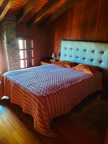 1 dormitorio con 1 cama grande y cabecero azul en CASA DE MADEIRA E PEDRA, en Afife