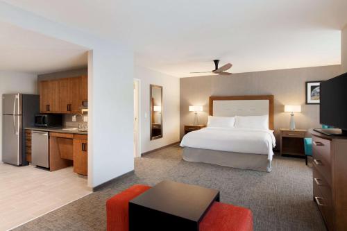 pokój hotelowy z łóżkiem i kuchnią w obiekcie Homewood Suites by Hilton Syracuse - Carrier Circle w mieście East Syracuse