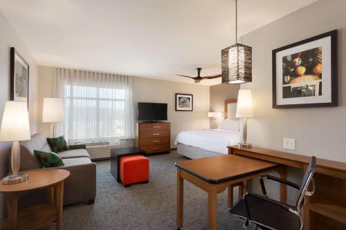 a large hotel room with a bed and a desk at Homewood Suites by Hilton Syracuse - Carrier Circle in East Syracuse