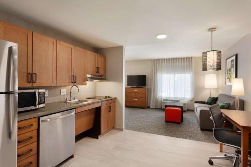 a kitchen and living room with a couch and a table at Homewood Suites by Hilton Syracuse - Carrier Circle in East Syracuse
