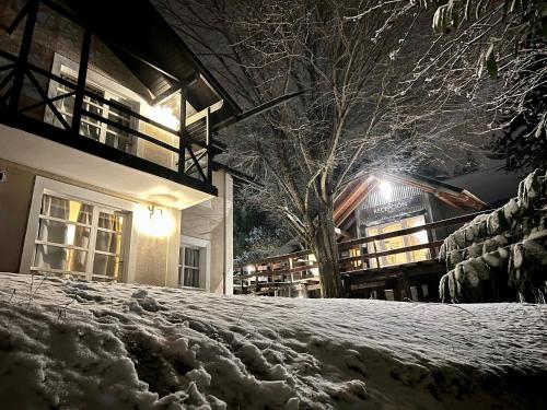 a building with a snow covered yard at night at Aldea Andina Hotel&Spa in San Carlos de Bariloche
