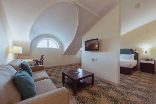 a living room with a couch and a bed at Hotel Skyler Syracuse, Tapestry Collection by Hilton in Syracuse