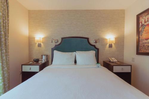 a bedroom with a large white bed with two night stands at Hotel Skyler Syracuse, Tapestry Collection by Hilton in Syracuse
