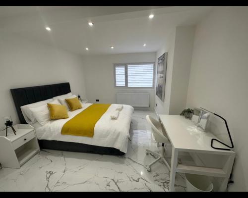 a bedroom with a large bed with a desk and a desk at Entire home in Nottingham in Nottingham