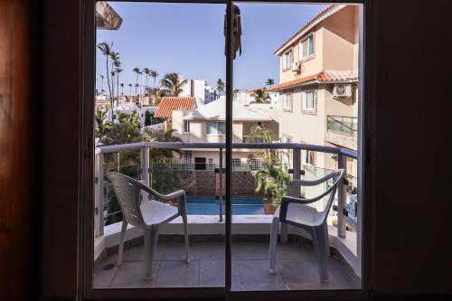 a balcony with two chairs and a view of a pool at Hotel Las Rosas de Punta Cana in Punta Cana