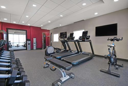 a gym with cardio machines and a flat screen tv at Home2 Suites By Hilton Utica, Ny in Utica