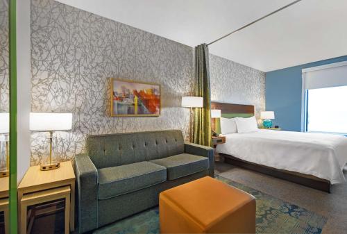 Habitación de hotel con cama y sofá en Home2 Suites By Hilton Utica, Ny, en Utica