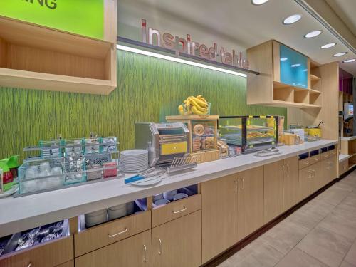 a fast food restaurant with a counter with food at Home2 Suites By Hilton Wayne, NJ in Wayne