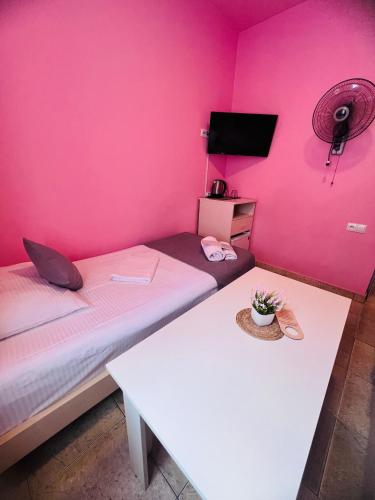a room with two beds and a pink wall at MarNar Hotel in Yerevan