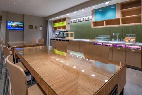 a restaurant with a large wooden table and chairs at Home2 Suites By Hilton Wayne, NJ in Wayne