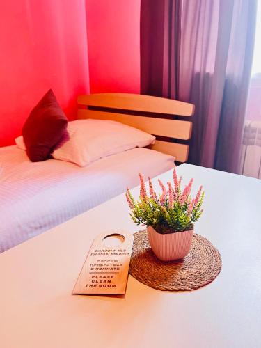 a table with a sign and a plant on a bed at MarNar Hotel in Yerevan