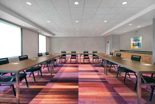 a large room with wooden tables and chairs at Home2 Suites By Hilton Utica, Ny in Utica