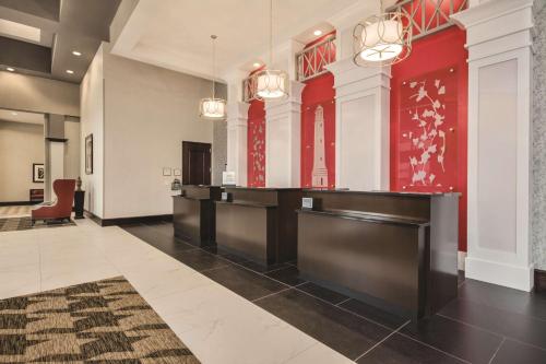 a lobby with a reception desk and red walls at Embassy Suites by Hilton Tuscaloosa Alabama Downtown in Tuscaloosa