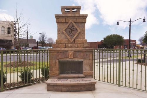 a brick fireplace in front of a fence at Embassy Suites by Hilton Tuscaloosa Alabama Downtown in Tuscaloosa