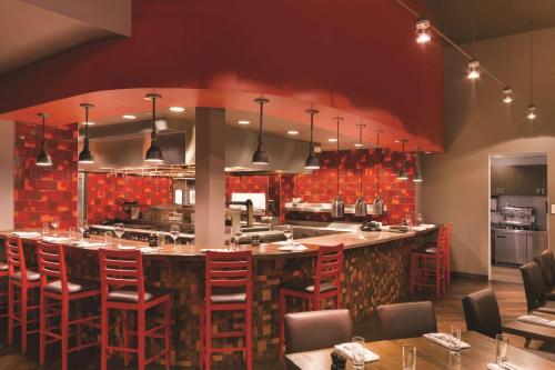 a kitchen with a large bar with red brick walls at Embassy Suites by Hilton Tuscaloosa Alabama Downtown in Tuscaloosa
