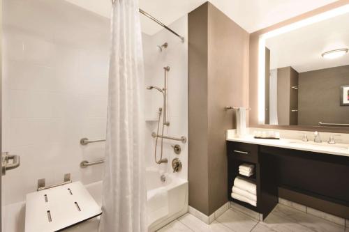 y baño con bañera, lavamanos y ducha. en Embassy Suites by Hilton Tuscaloosa Alabama Downtown, en Tuscaloosa