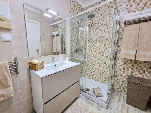 a bathroom with a sink and a shower at Apartment Praia Rocha Seashell in Portimão