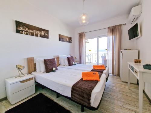 ポルティマンにあるApartment Praia Rocha Seashellのベッド、デスク、ベッドが備わるホテルルームです。