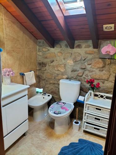 uma casa de banho com um WC e um lavatório em CASA DE MADEIRA E PEDRA em Afife