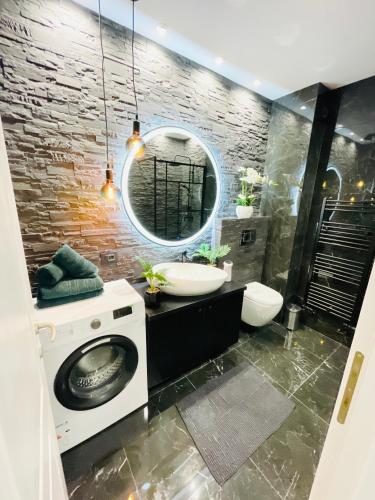 a bathroom with a sink and a washing machine at Aici te simți ca acasa 2 in Iaşi