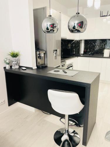 a black counter with a white chair in a kitchen at Aici te simți ca acasa 2 in Iaşi