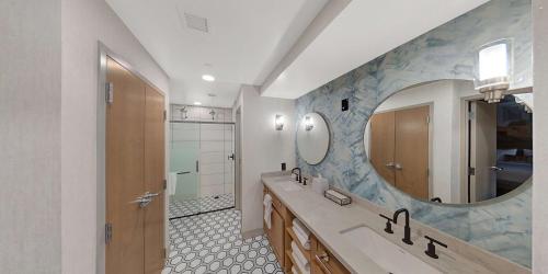 een badkamer met een grote spiegel en een wastafel bij Hilton Garden Inn Toledo Downtown in Toledo