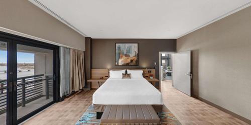 a hotel room with a bed and a balcony at Hilton Garden Inn Toledo Downtown in Toledo