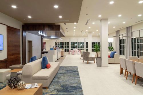 an office lobby with couches and tables and chairs at Hilton Garden Inn Tampa - Wesley Chapel in Wesley Chapel
