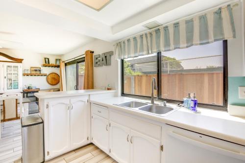 a kitchen with white cabinets and a sink and a window at Solana Beach Condo with 4 Pools and Beach Access! in Solana Beach