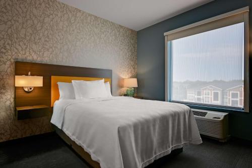 a bedroom with a large bed and a large window at Home2 Suites By Hilton Temple in Temple