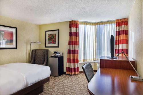 a hotel room with a bed and a desk with a computer at DoubleTree by Hilton Johnson City in Johnson City