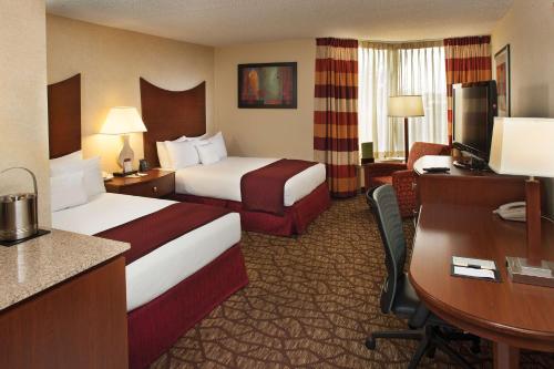 a hotel room with two beds and a desk at DoubleTree by Hilton Johnson City in Johnson City