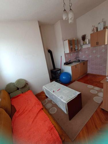 a living room with a red bed and a kitchen at Apartments Emir in Kiseljak